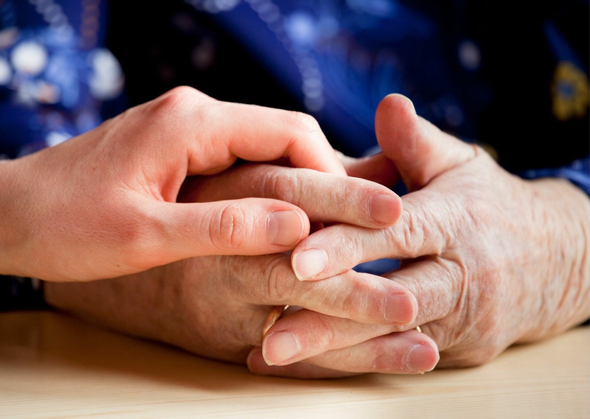 A young person holding the hands of an older relative