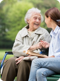 woman with live in care staff in park